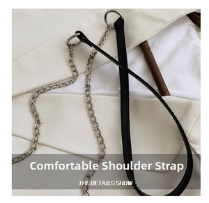 Close-up of the silver metal chain and black leather shoulder strap of the bag