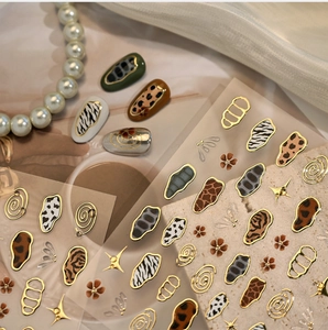 Detailed animal print nail stickers featuring leopard and zebra patterns with gold accents
