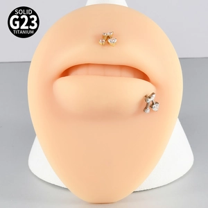 Dettaglio del piercing al labbro in titanio G23 a forma di ciliegia con zircone