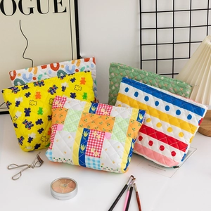 Detailed close-up of quilted floral and bear pattern cotton cosmetic pouches with zippers