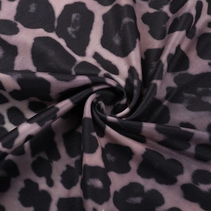 Detail of leopard print fabric with black-brown spots on pink-purple base with pleats
