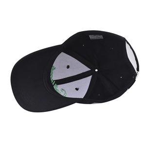 Detailed interior of black cotton baseball cap showing white lining and green embroidery