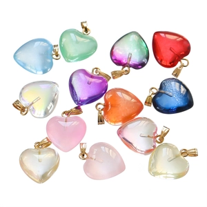 Macro shot of colorful acrylic heart pendants with glossy finish and golden metal loops