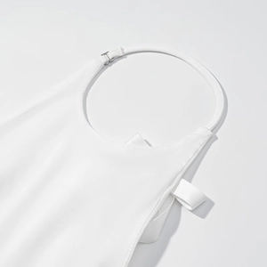 Détail du haut dos nu blanc avec tissu de qualité et boucle en métal argenté brillant