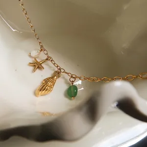 Gold ocean necklace with starfish shell pearl and green gemstone pendant charms