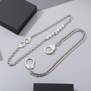 Détail du collier punk argenté avec menottes, perles et pendentif en forme de cœur