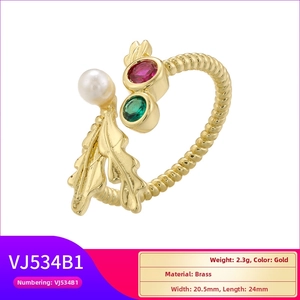 Detail view of brass open ring with gold leaf, white pearl and colored gemstones