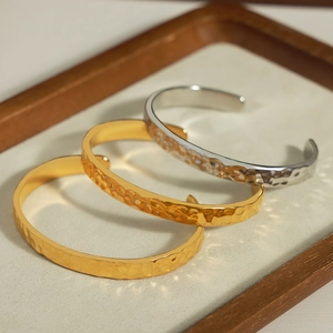 Bracciali aperti minimalisti in acciaio al titanio martellato oro e argento su vassoio