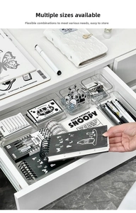 Close-up of clear acrylic drawer organizer bins for stationery and desk storage