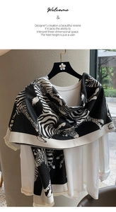 Detail of bohemian black and white zebra pattern knit shawl with fringe on white shirt
