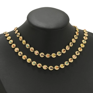 Detail of gold sun-disk chain necklace featuring colorful enamel beads on a neck display