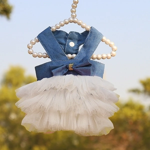Detail of blue denim pet dress with layered white tulle skirt and bow on pearl hanger