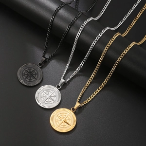 Compass pendant necklaces in black, silver, and gold with detailed compass rose engraving