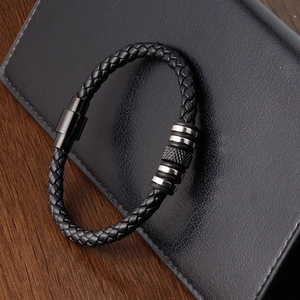 Men's black braided leather bracelet with stainless steel beads on leather wallet