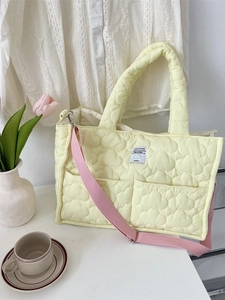 Pale yellow quilted tote bag with cloud patterns and a pink shoulder strap in soft fabric