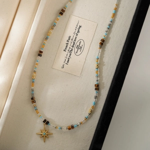 Macro shot of tiger eye beaded necklace with a golden star pendant in a jewelry box