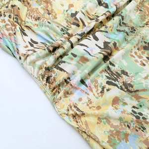 Close-up of abstract floral print fabric with sparkling gold sequin trim detail