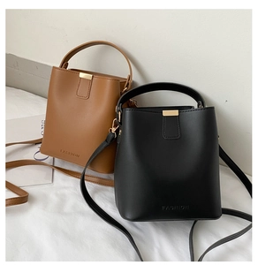 Details von minimalistischen Eimertaschen in Braun und Schwarz mit geprägter Aufschrift