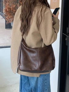 Close-up of retro dark brown PU leather hobo bag with vintage texture and stitched detail