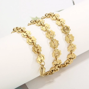 Detail of golden gear link chain necklace with polished finish and lobster clasp