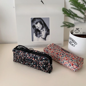 Close-up of floral corduroy pencil cases with zippers and merciparis brand label