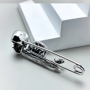 Detailed view of punk gothic safety pin brooch with retro silver skull and bone texture