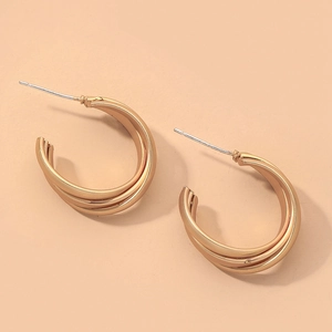 Détail des boucles d'oreilles créoles triple C géométriques dorées avec tiges en argent