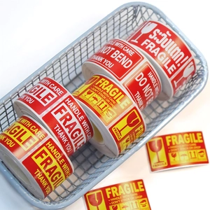 Roll of red and yellow Fragile Handle With Care warning stickers in a wire basket