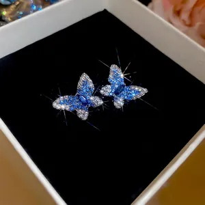 Boucles d'oreilles papillon élégantes avec zircons dégradés bleu et blanc sur velours