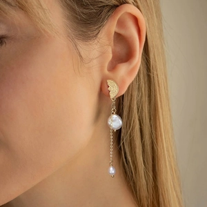 Macro view of vintage gold drop earrings with baroque pearl and teardrop accents