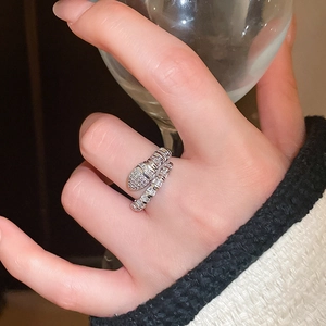 Macro shot of silver snake ring with sparkling cubic zirconia on a model hand