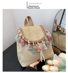Detail of khaki straw backpack featuring colorful tassels and woven textures for beach style