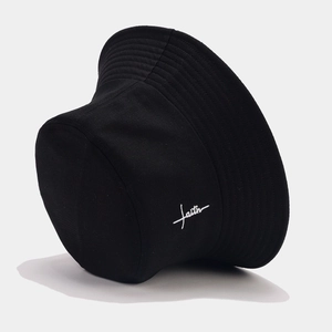 Detail of white faith embroidery on a black cotton bucket hat with street style stitching