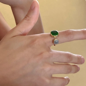 Adjustable gold ring featuring square green and grey gemstones worn by model