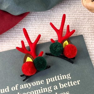 Detail von Weihnachts-Rentier-Haarspangen mit festlichem rotem Samt und Plüsch-Pompons