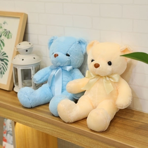 Lindos ositos de peluche azules y crema en un estante de madera en una habitación cálida.