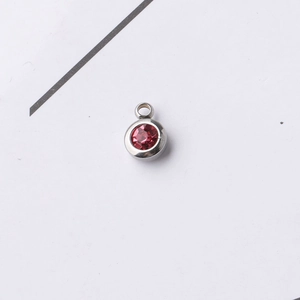 Detailed macro view of a 6.5mm red round birthstone pendant in silver stainless steel