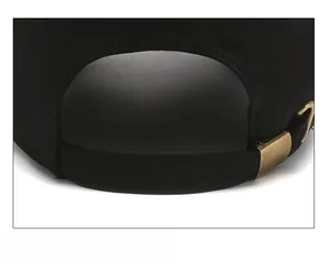 Close-up of the adjustable strap and vintage copper buckle on the black cotton baseball cap