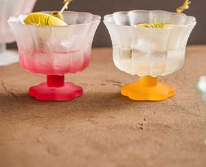 Detail view of flower-shaped frosted glass dessert bowls with citrus and herb garnishes