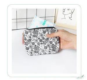 Detailed shot of paisley coin purse with tassel showing internal sanitary pad storage capacity