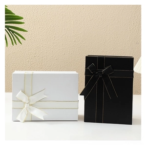 Detail of black and white gift boxes featuring gold stitching and matching silk ribbons