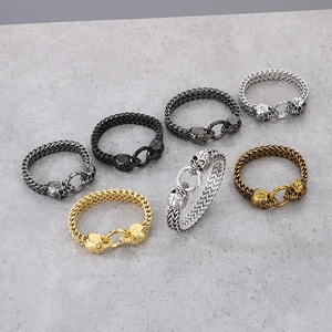 Detailed array of punk skull bracelets in various metal finishes on marble stone background