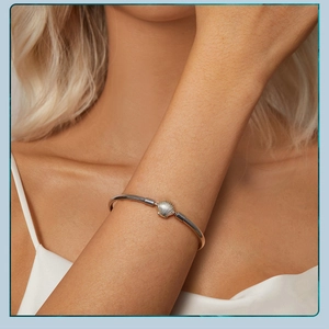 Close-up of elegant s925 silver cuff bracelet with seashell detail worn by a model