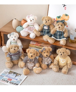 Detail view of plush teddy bears in stylish outfits like plaid dresses and knit sweaters