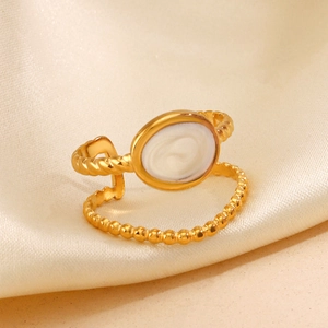 Golden double-layer geometric oval ring with white inlay on beige silk background
