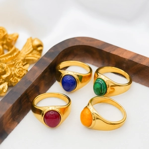 Detail of vintage 18k gold plated rings with colorful agate stones on a wooden stand