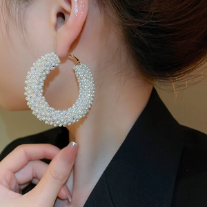 Detailed view of silver needle C-shaped earrings featuring dense pearls and rhinestones