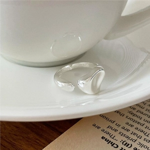 Minimalist 925 sterling silver irregular heart ring on a white ceramic plate