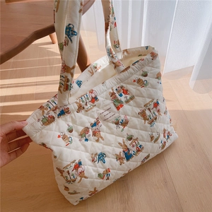 Detailed close-up of quilted cotton fabric with vintage rabbit print and French woven label