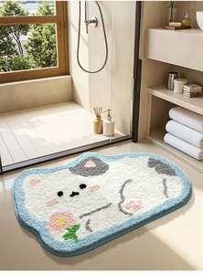 Close-up of a cartoon cow-shaped plush bath mat with soft tufted texture in a modern bathroom